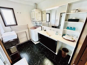 A modern bathroom with a black marble floor, a white sink, a mirror, and a towel rack. - ZOE RESORT THE Sunset Village OKINAWA CHATAN (Chatan)