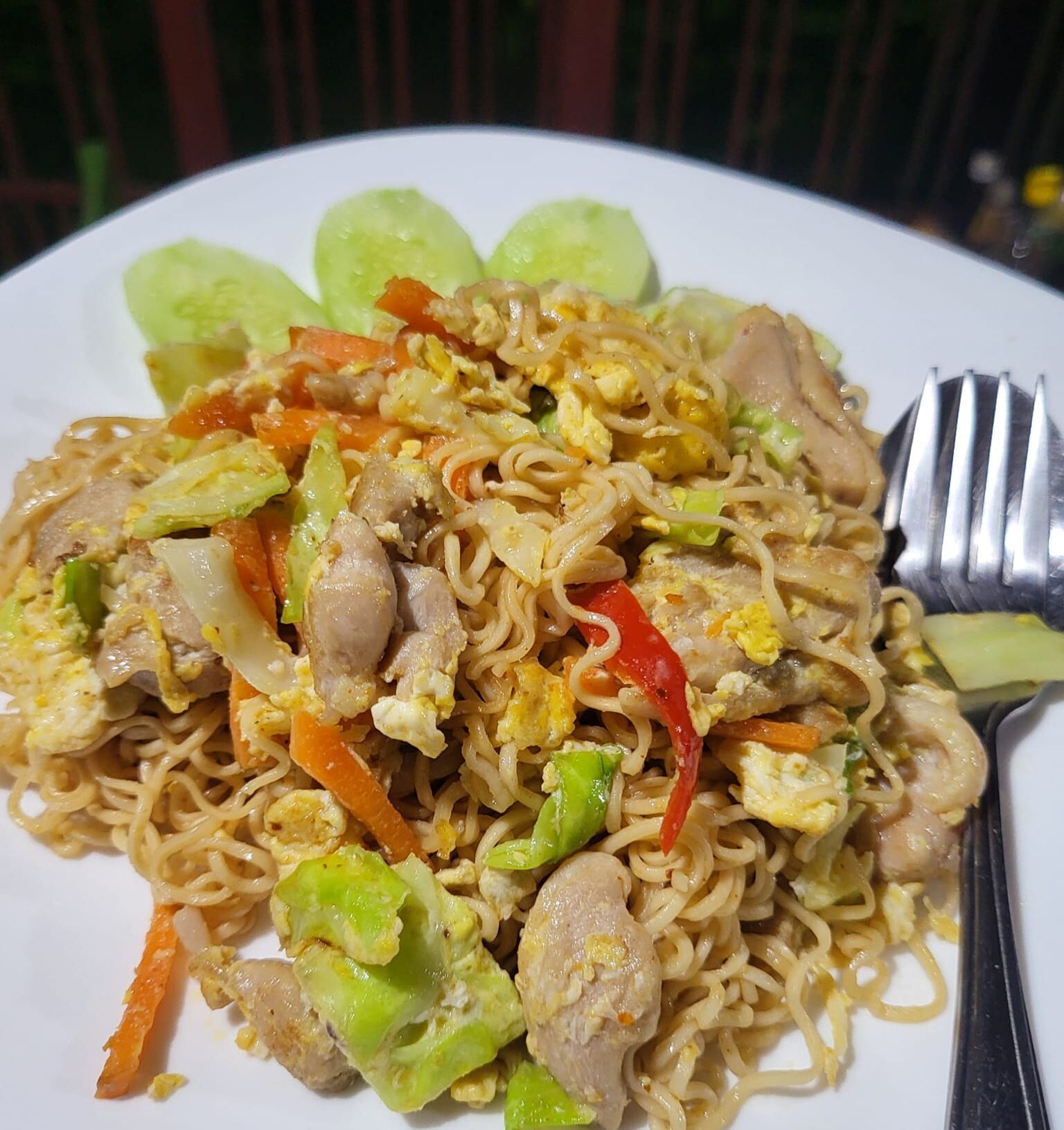 Un plato de fideos salteados con verduras y carne.