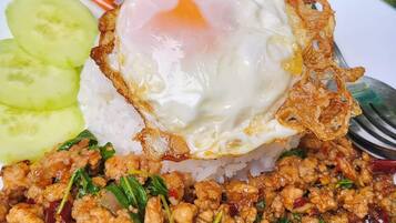 A plate of food with rice, a fried egg, and stir-fried meat.