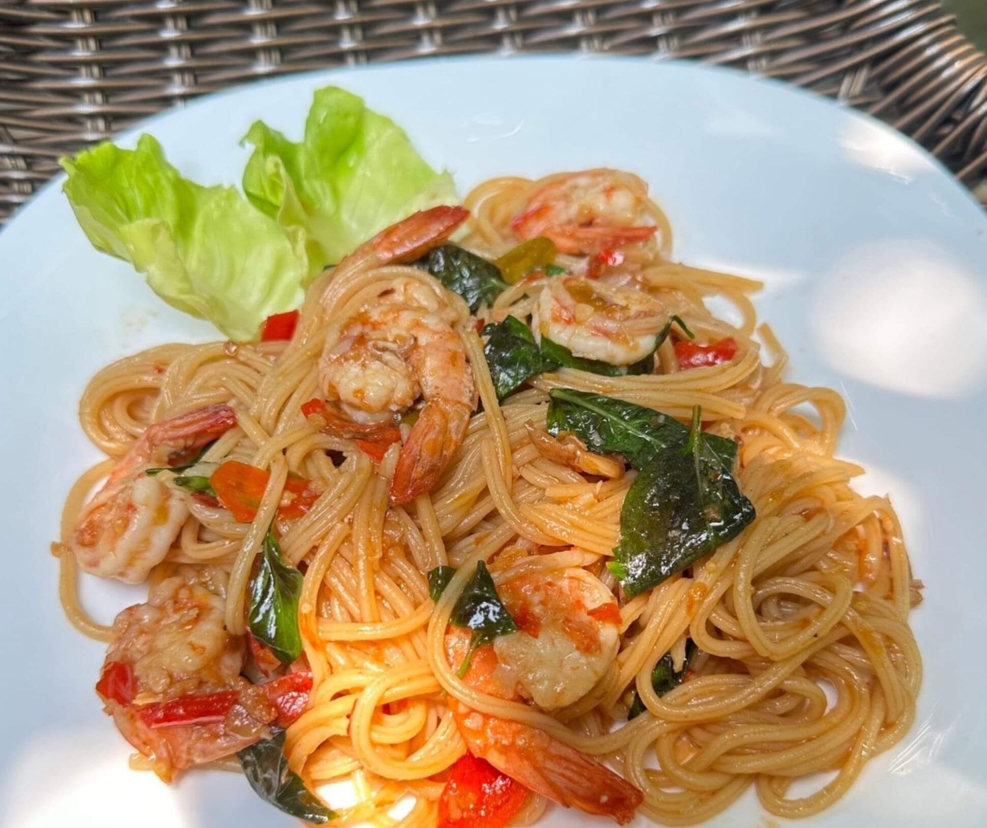 A plate of stir-fried noodles with shrimp and vegetables.