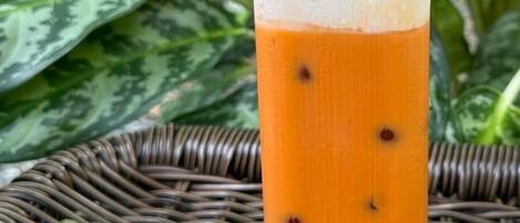 Un vaso de té helado con perlas de tapioca sobre un posavasos tejido.