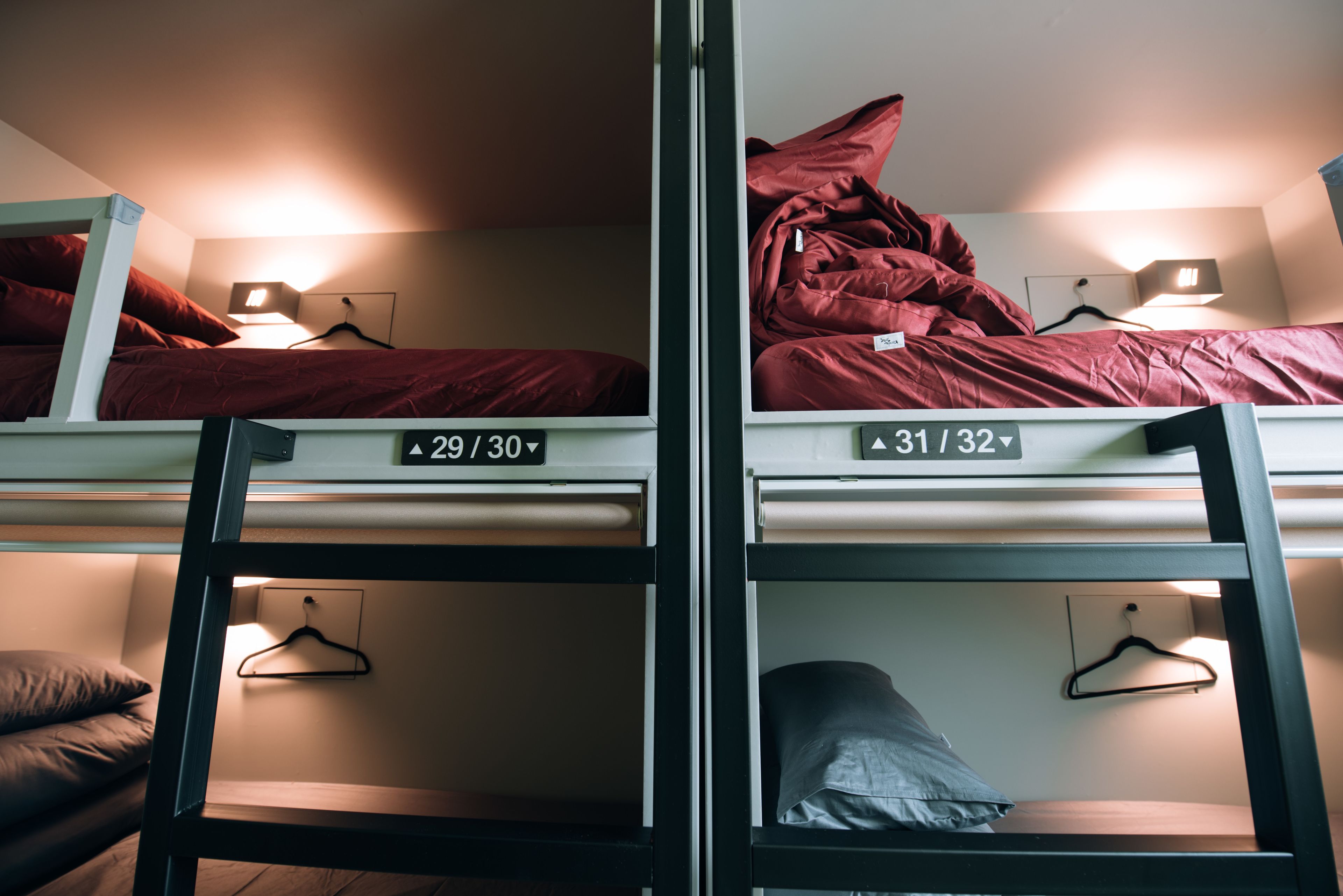 Un dortoir équipé de lits superposés, chacun étant identifié par un numéro et une taille.