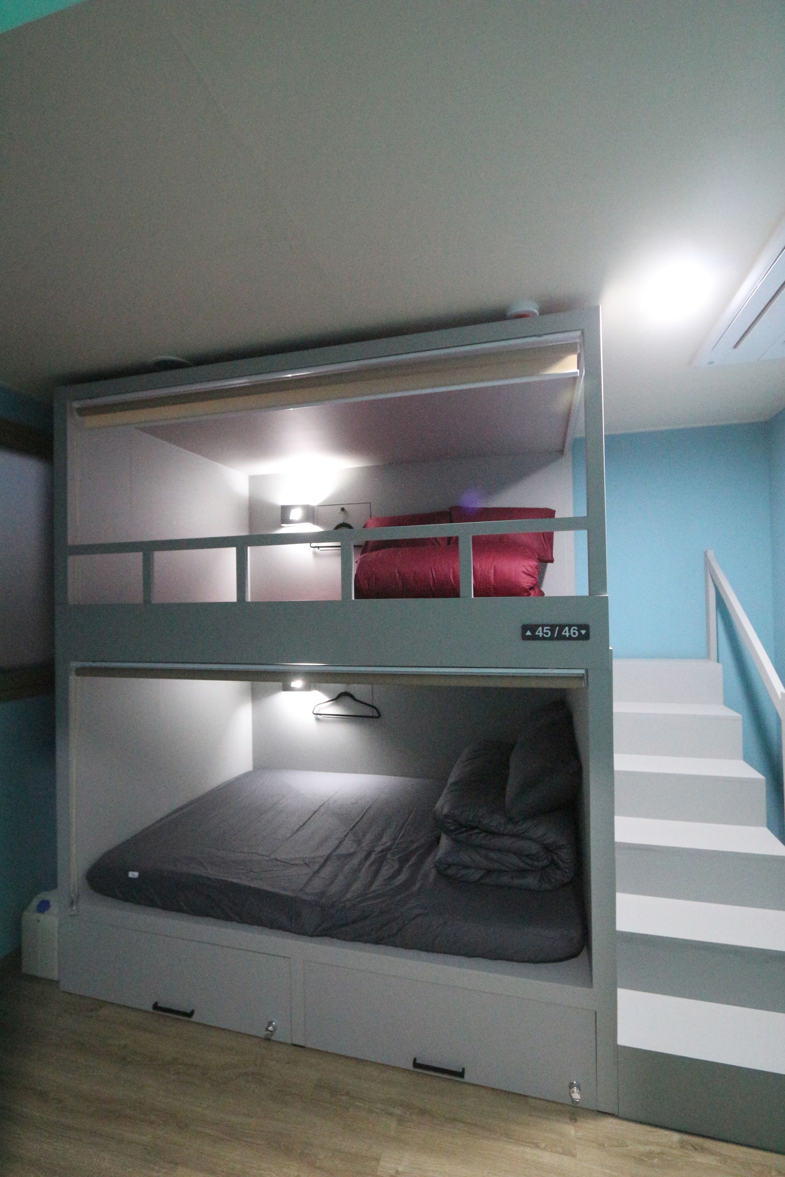 Habitación con literas y una escalera a la derecha.