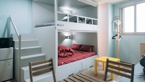 A bunk bed room with a desk and chair, a small table, and a coat rack. - Midtown Hostel (Daegu)