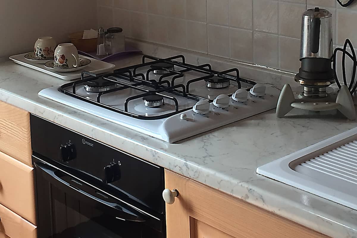 A kitchen with a gas stove, oven, and a microwave.