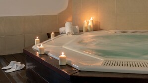 A hot tub with candles, a towel, and slippers on a wooden bench. - Kinar Galil (Ramot)