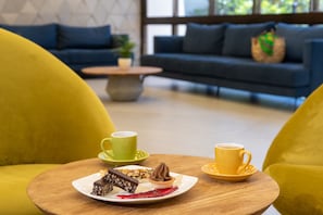 Une table à manger avec une assiette à dessert, deux tasses et une tasse à café.