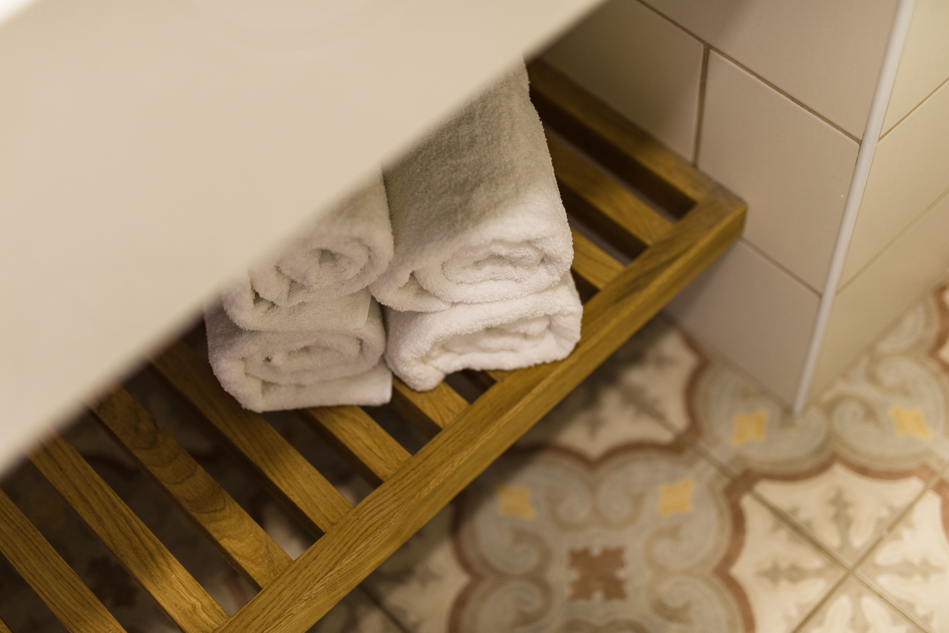A wooden shelf with folded white towels.