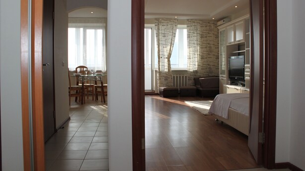 Una habitación de hotel con cama, televisión, zona de estar con mesa y sillas, y vistas al exterior por una ventana.