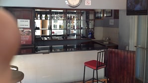 Zona de bar con un reloj, letrero de bar y un cartel de prohibido fumar.
