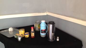 A kitchen counter with various items including a coffee maker, jars, and containers.