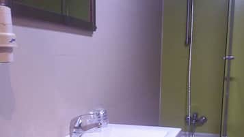 A bathroom with a sink, mirror, and shower.