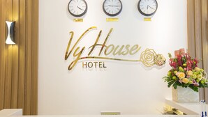 Een receptiebalie met klokken die de tijd weergeven voor Hanoi, Londen en Seoul.