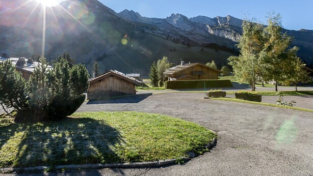Un paysage de montagne avec une cabane en bois et une pelouse bien entretenue.