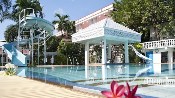 Ein Schwimmbecken mit Wasserrutsche und einem Pavillon.