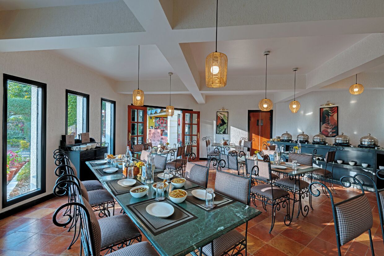 A dining area with a long table set for a meal, surrounded by chairs.
