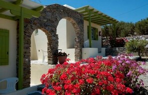 A building with stone arches and a covered patio area. - Asante Paros (Paros)