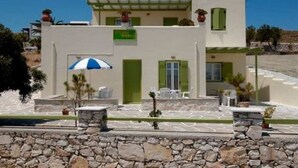 A white building with green shutters, a sign reading "SOKOL", and outdoor seating. - Asante Paros (Paros)