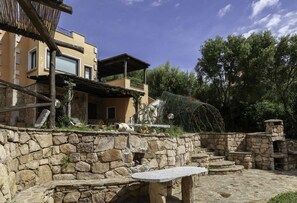 A stone wall with a stone bench and steps leading to a stone structure. - ARIA DI VACANZA - PEDRA LONGA COD.21 (Olbia)