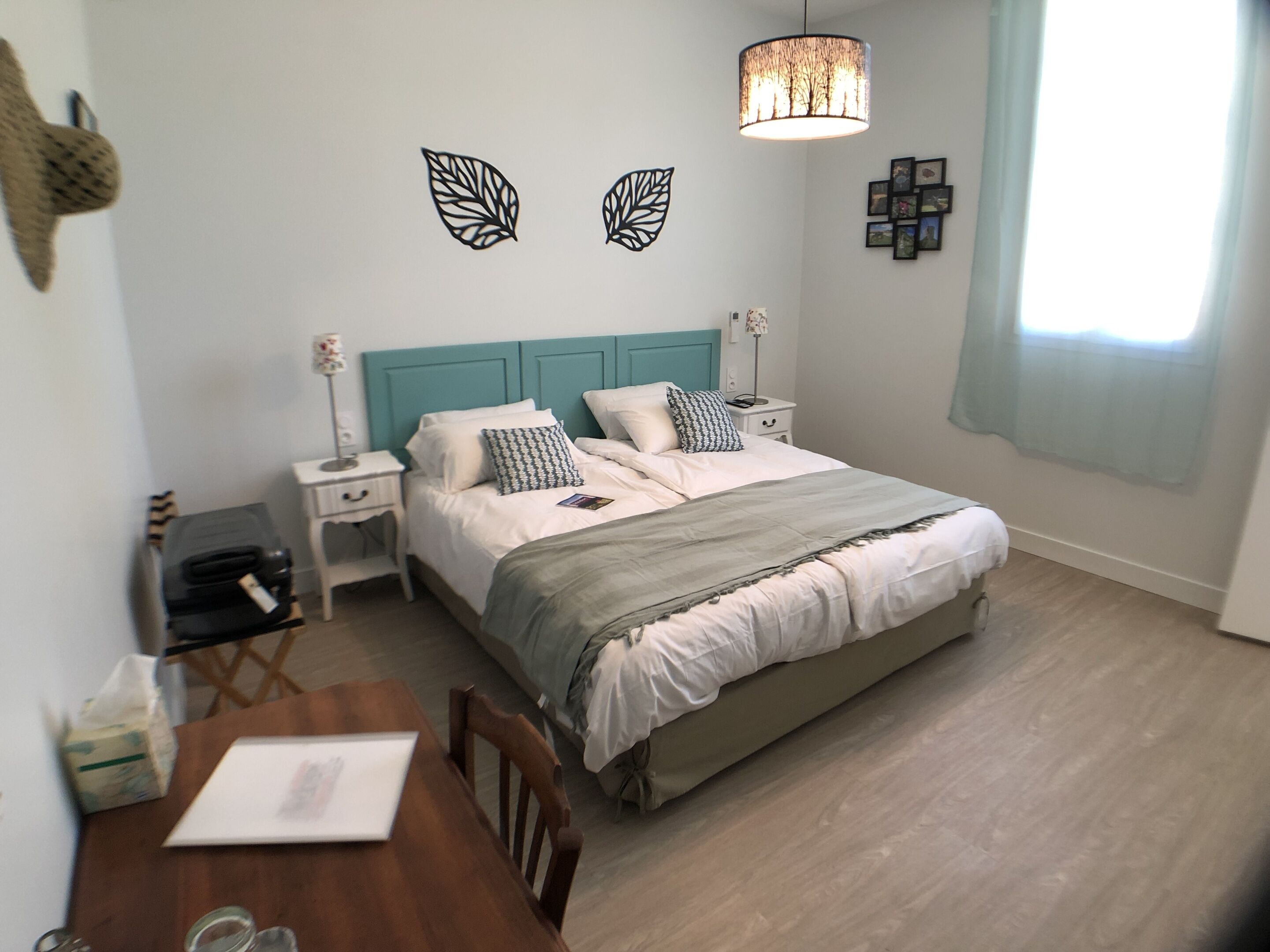Ein Schlafzimmer mit einem Bett, Nachttischen, einem Schreibtisch und einem Stuhl.