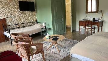 Une chambre à coucher avec un lit, un bureau, une chaise, une télévision et une valise.