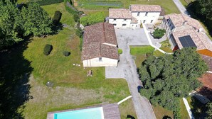 Vista aérea de una zona residencial con piscina, casas y jardines cuidados.