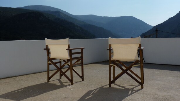 Two wooden chairs with canvas seats on a balcony overlooking a mountainous landscape. - Viva Elafonisi (Kissamos)