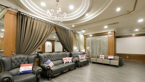 A hotel lobby with a grand chandelier, leather sofas with flags, and a large screen wall. - Nanka Express Hotel (Chiayi City)