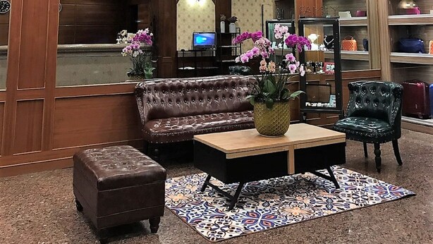 A lobby with a round ceiling, a reception desk, a sofa, a coffee table, and a chair. - Nanka Express Hotel (Chiayi City)