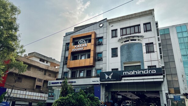 A multi-story building with a sign for 'Karan Holiday' on the second floor. - Karan Holidays (New Delhi)