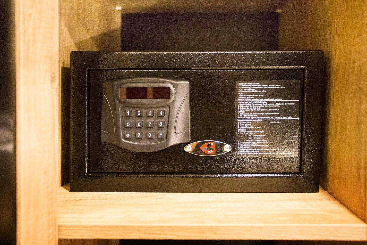 A security keypad with instructions, housed in a wooden frame.