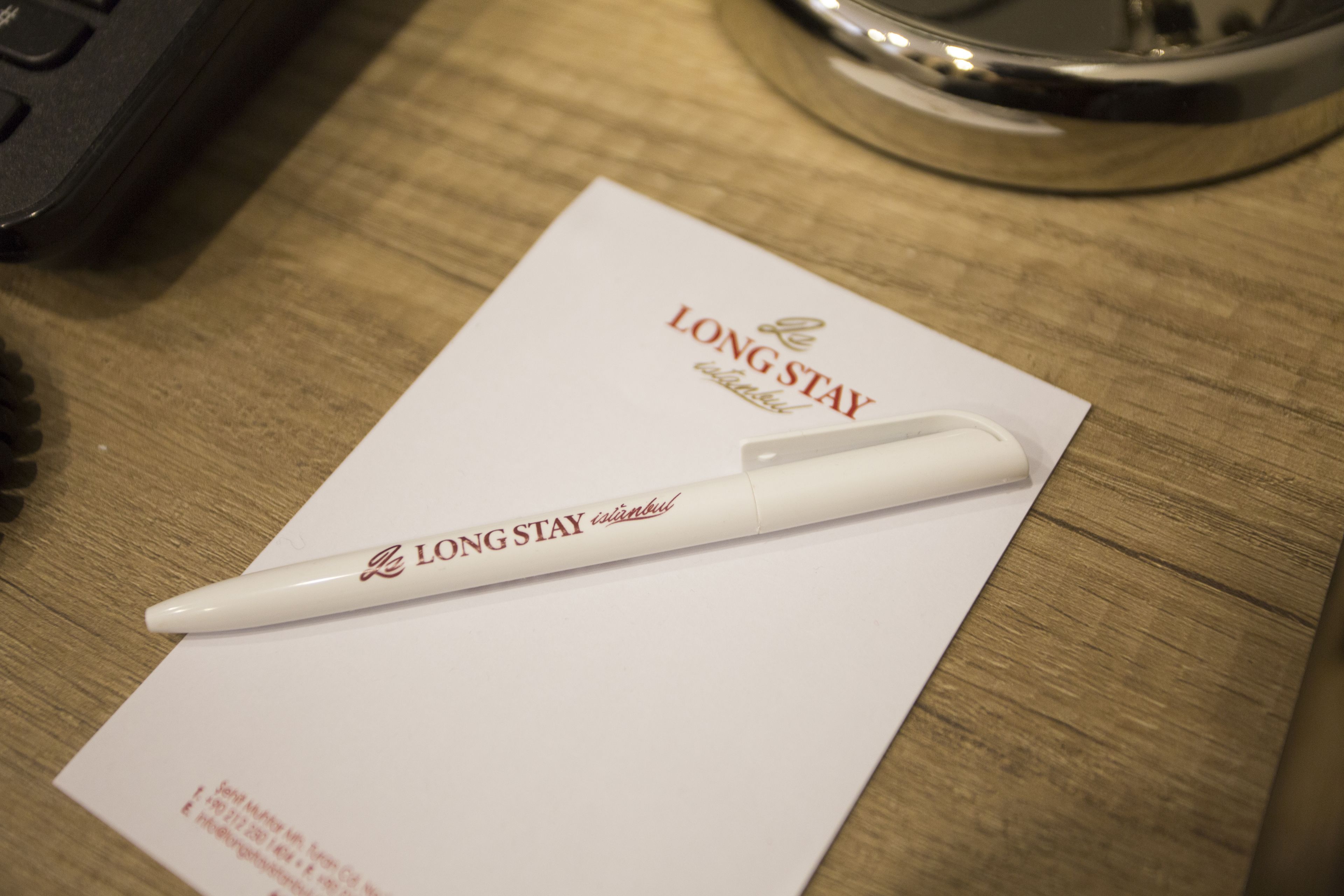 Una penna bianca su un foglio bianco con la scritta "LONG STAY" e "Istanbul".