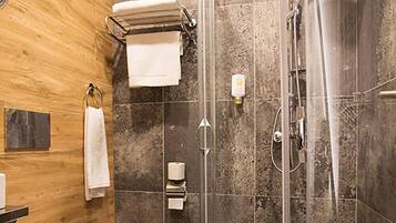 Un baño moderno con ducha de vidrio, inodoro y barra para toallas.