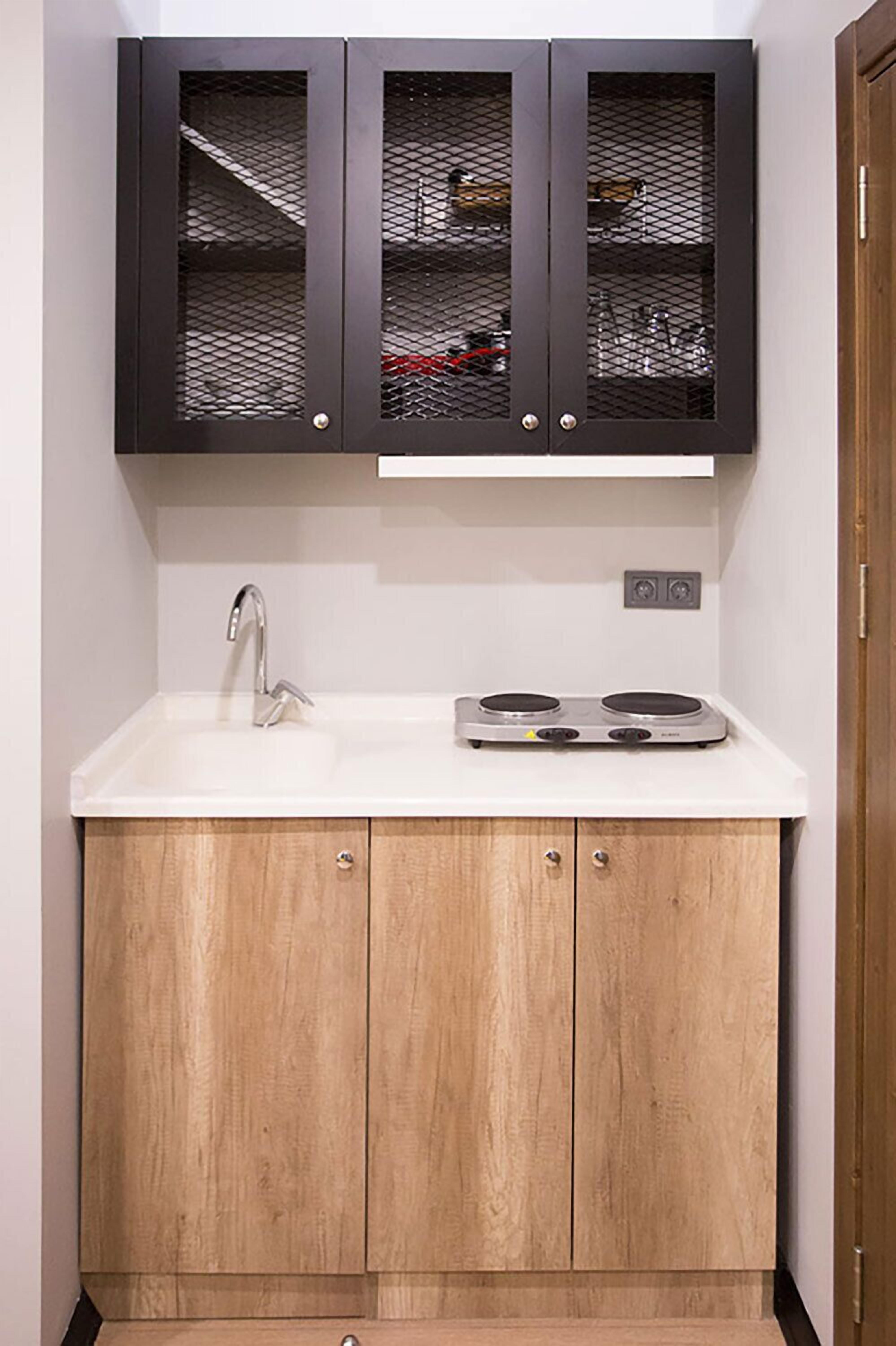 A kitchen with a white countertop, a stainless steel sink, and a double electric stove.
