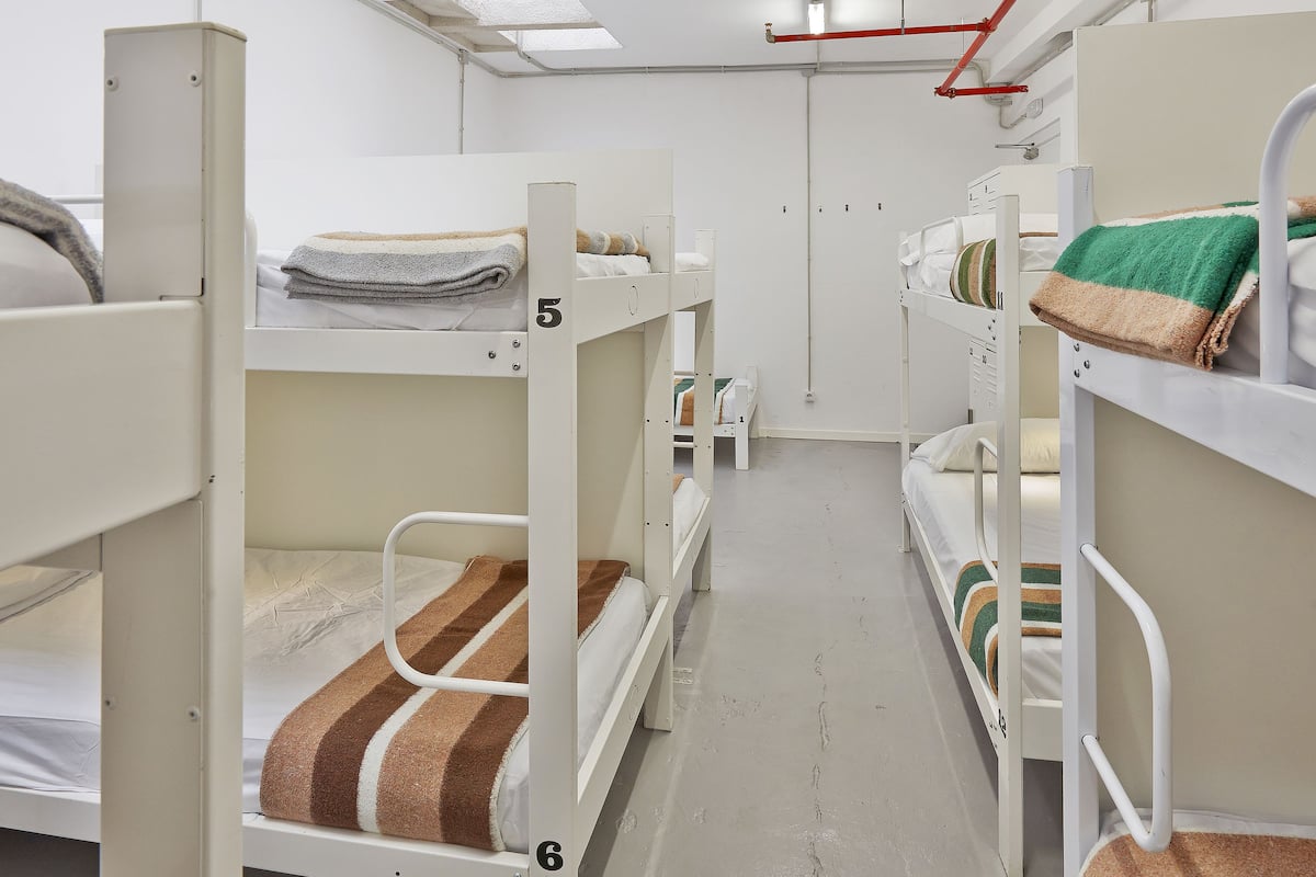 A dormitory room with bunk beds, numbered 5 and 6, and a skylight above.