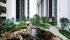 Ein moderner Innenbereich mit Gartenanlage, inklusive Wasserspiel, umgeben von großen Fenstern und zeitgenössischer Architektur.