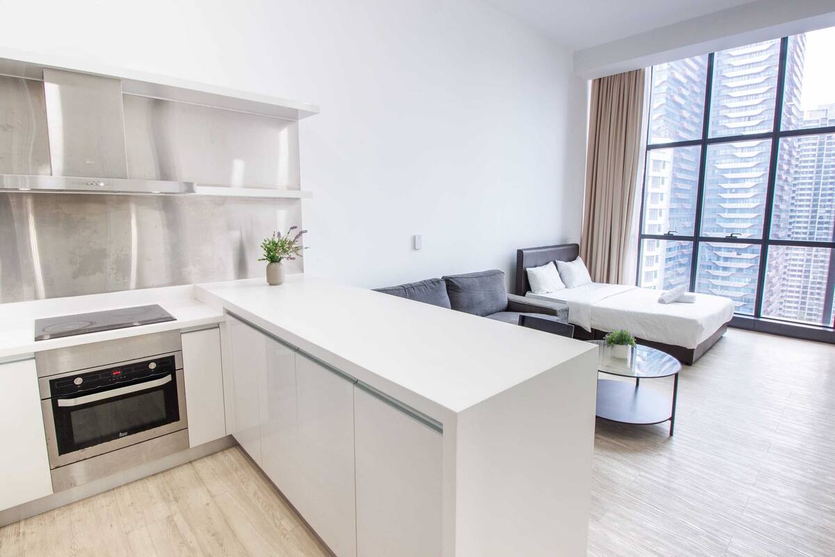 A modern kitchen with a built-in oven and a dining area with a glass table.