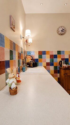 A kitchen with a tiled backsplash, a sink, a coffee maker, and a wooden cabinet. -  Maison de Maître Gentil'Home - 1699 (Fenouillet)