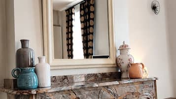 Une salle de bain avec un lavabo en marbre, un miroir et une baignoire noire.