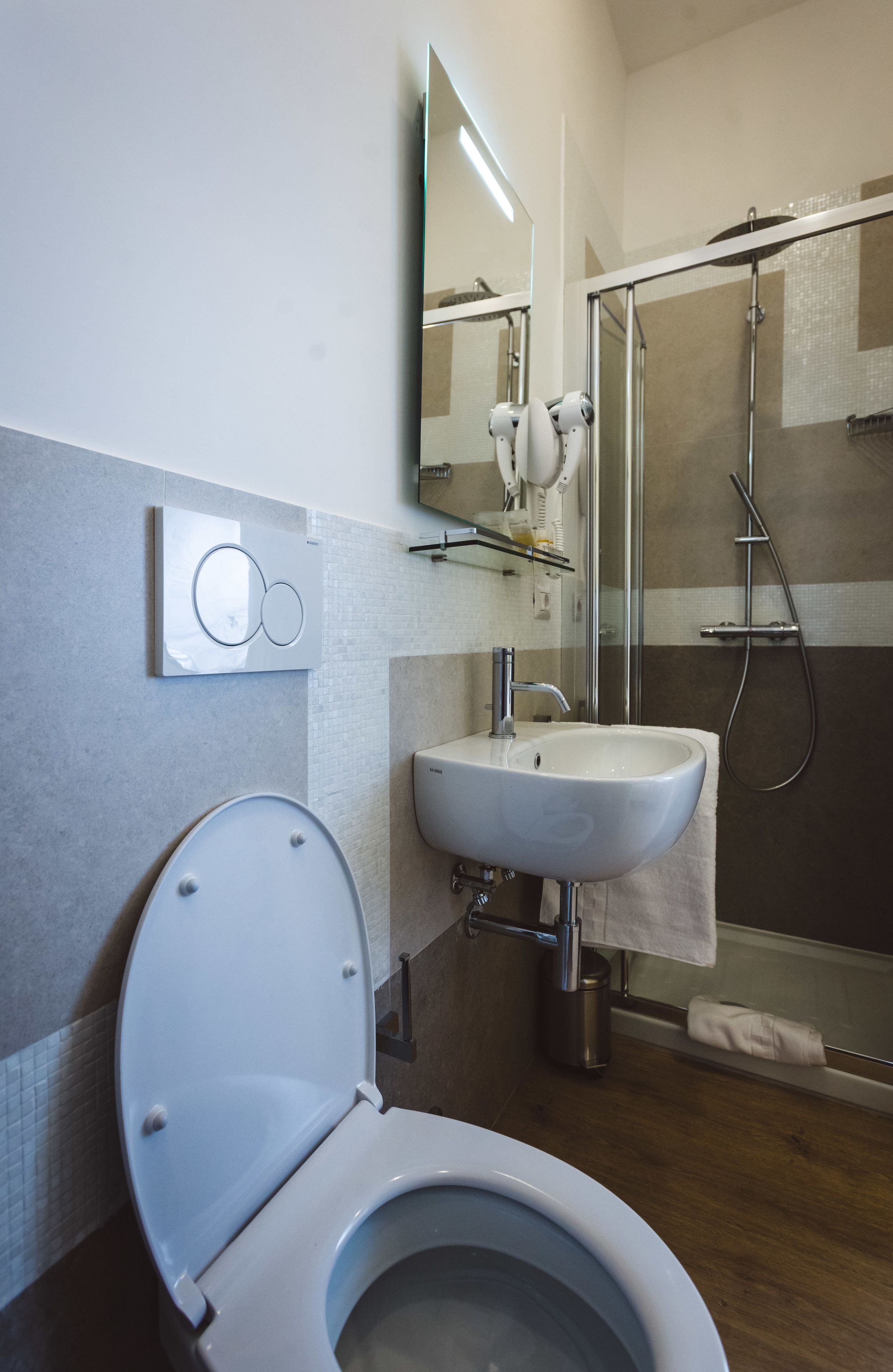 Un baño moderno con inodoro, lavamanos y ducha.