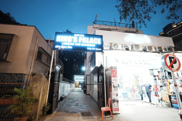 A hotel entrance with a sign reading "King's Palace" and "Lodging and Boarding."
