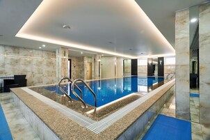 Una piscina techada, sillones reclinables de piscina