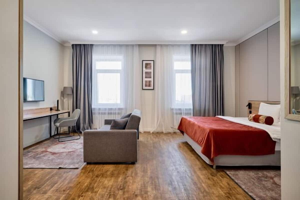 Une chambre d’hôtel moderne équipée d’un lit, d’un bureau, d’une chaise et d’un canapé.
