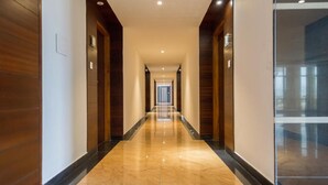 Un largo pasillo pulido con paneles de madera en las paredes y un suelo de mármol brillante.