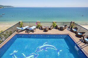 Piscina com vista clara para o mar e a praia.