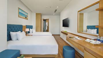 A hotel room with two beds, a desk, a mirror, a television, and a painting on the wall.