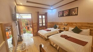 A hotel room with two beds, a wooden headboard, a small table, and a view of the outdoor area. - Dang Khoa Garden Inn (Sa Pa)