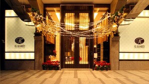 A hotel entrance with a grand archway, decorative lights, and potted plants. - Taipei K House (Taipei)
