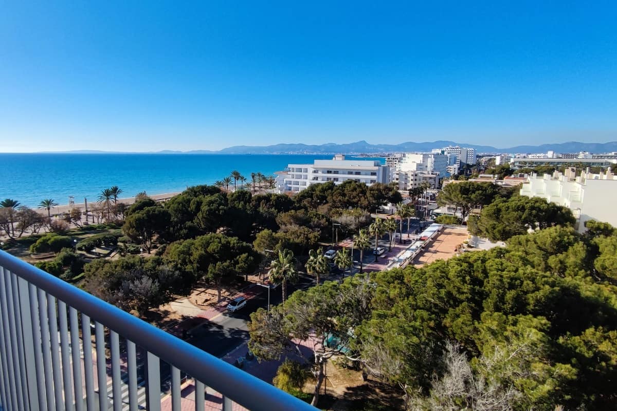 Un paysage urbain côtier avec des bâtiments, une plage et un ciel bleu dégagé.