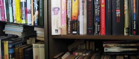 A bookshelf filled with various books, some with visible titles and authors.